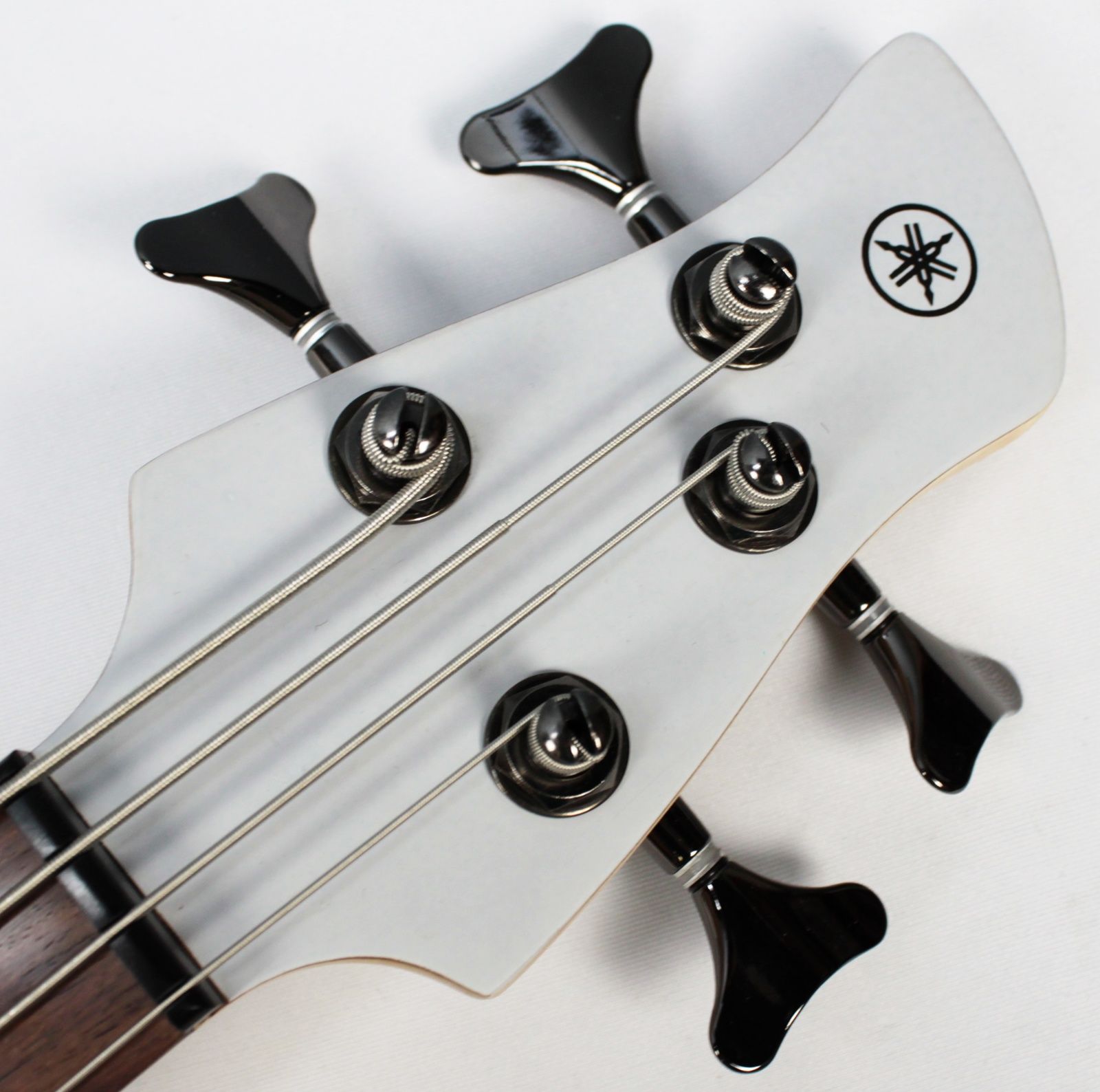 Yamaha TRBX304 4-string bass white front of headstock