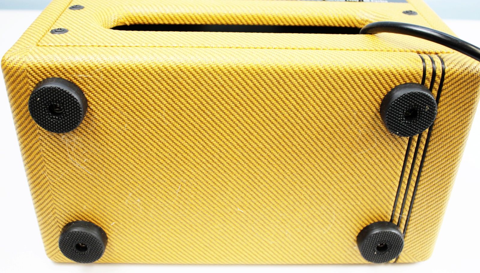 Detail shot of the tweed covering showing minor blemishes and lacquer texture. Legs